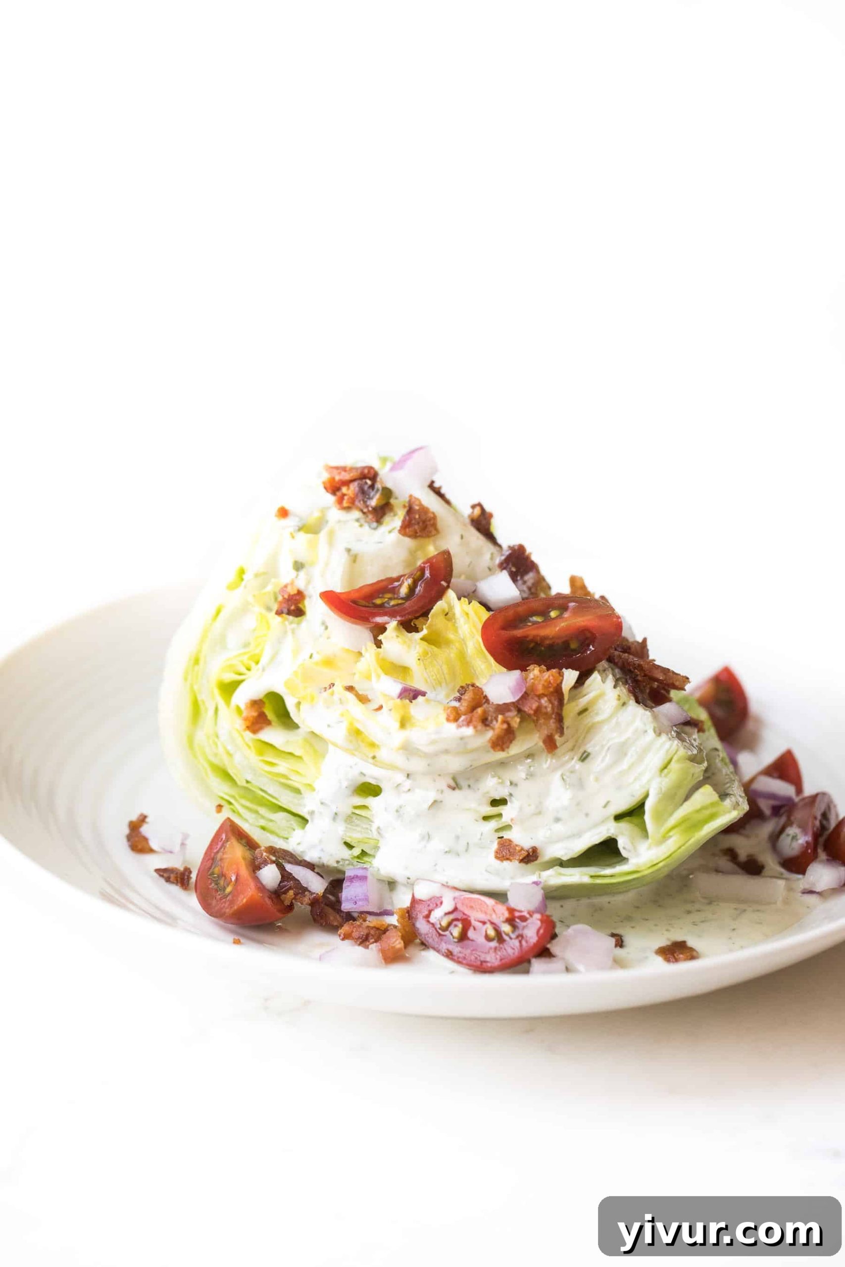 Close-up of a refreshing Whole30 Keto Wedge Salad with generous toppings of bacon, tomato, and onion