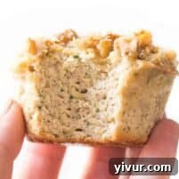 hand holding a paleo zucchini muffin on a white background