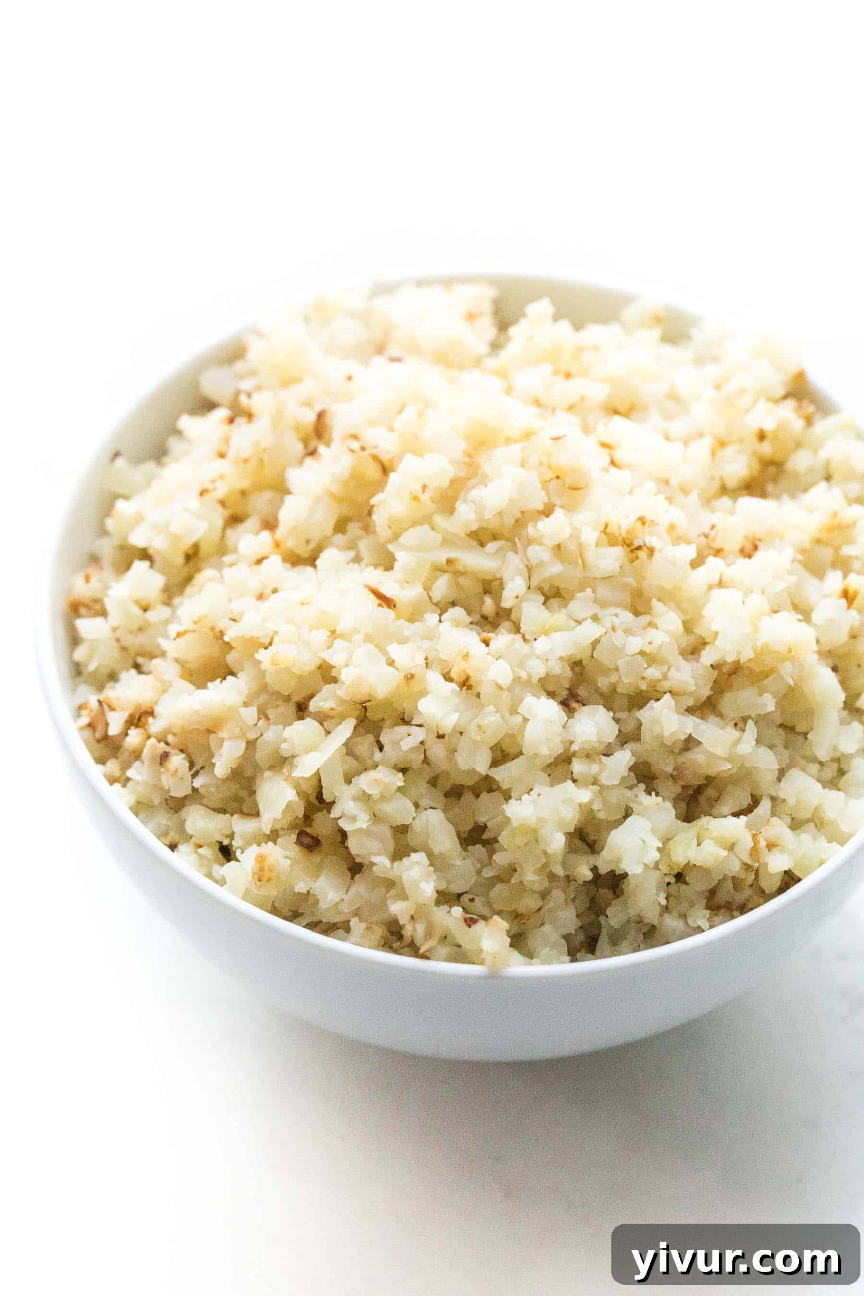 Quick and Easy Frozen Cauliflower Rice Hack 2 Perfectly cooked cauliflower rice in a white bowl, ready to serve.