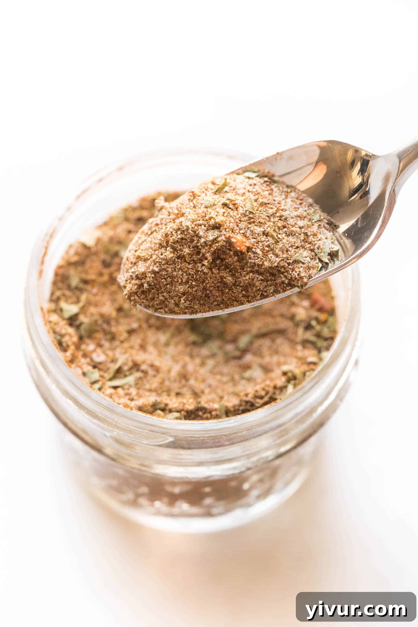 spoon holding jamaican jerk seasoning on a white background