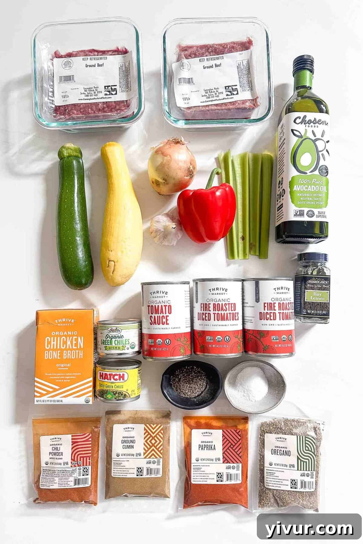 Keto Whole30 Instant Pot Chili Beanless and Easy 3 A colorful array of fresh, raw ingredients laid out on a clean white surface, including chopped yellow onion, zucchini, yellow squash, red bell pepper, and celery, ready for making Whole30 keto chili.