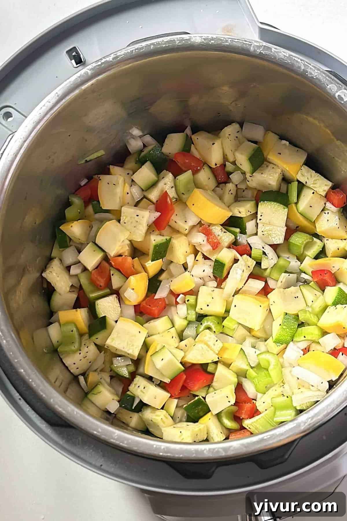 Keto Whole30 Instant Pot Chili Beanless and Easy 4 Chopped yellow onions, zucchini, yellow squash, celery, and red bell pepper sautéing in avocado oil inside an Instant Pot, building the aromatic base for the keto chili.