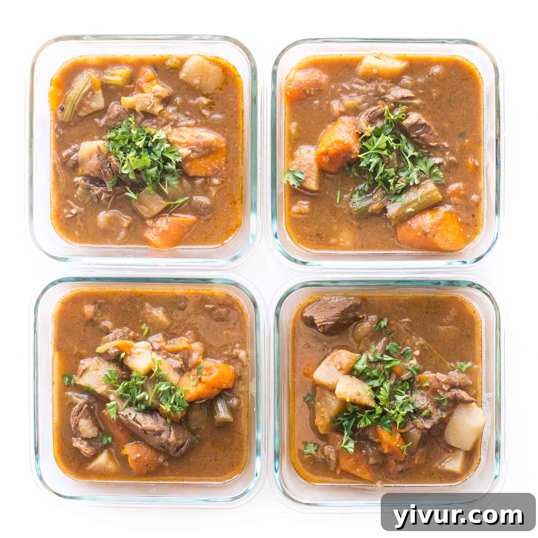 Portioned servings of Whole30 Keto Instant Pot Beef Stew neatly arranged in glass meal prep containers, ready for the week, on a clean white background.