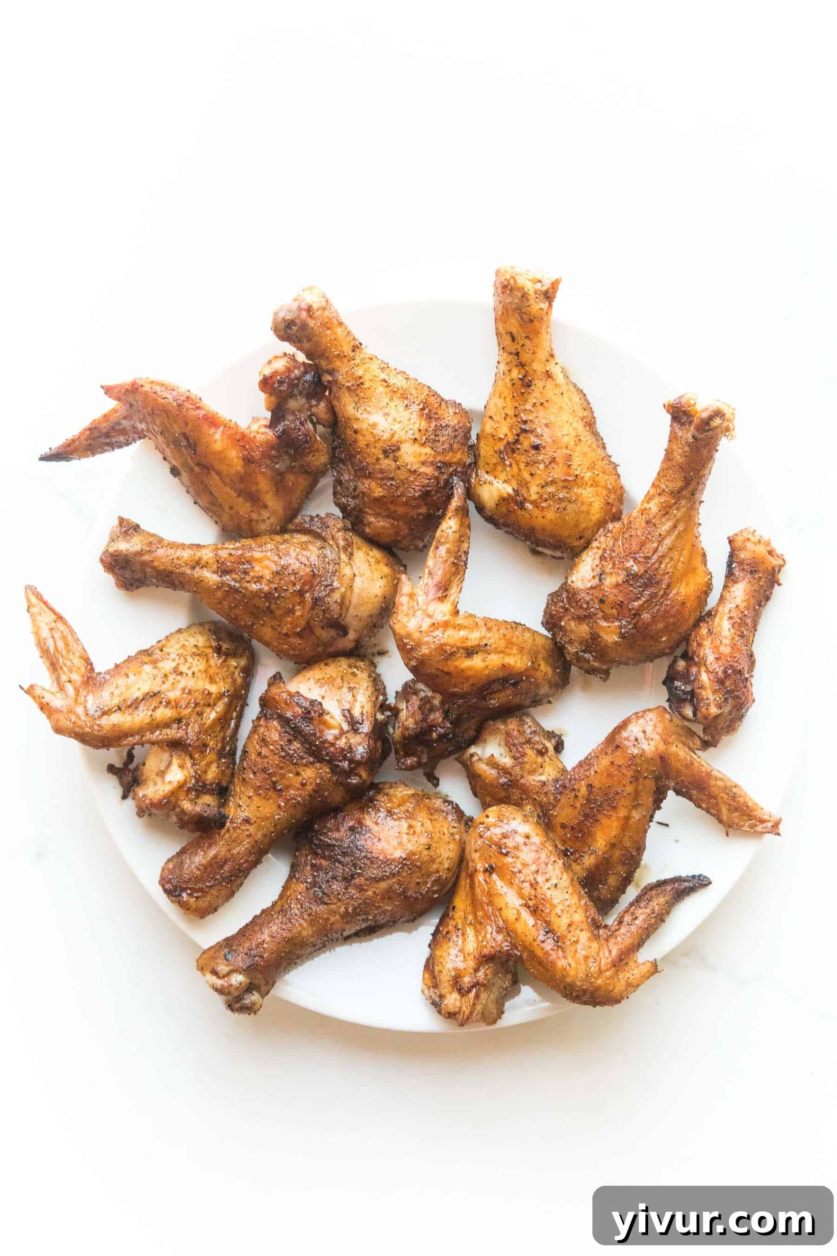 Golden Crispy Whole30 & Keto Chicken Drumsticks and Wings 3 crispy roasted drumsticks + wings on a white plate and background
