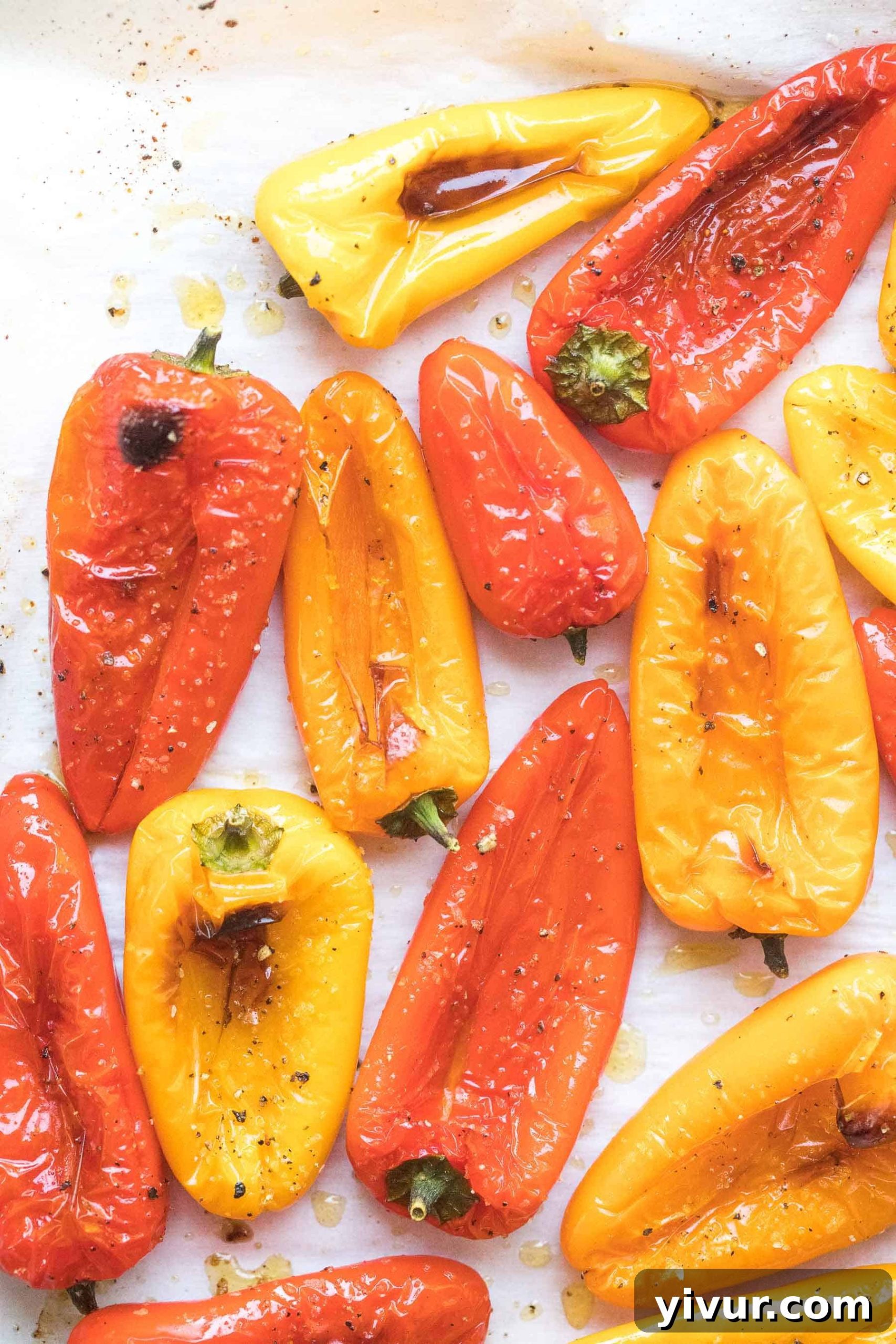 Close-up of golden brown roasted mini bell peppers on parchment paper, ready to serve
