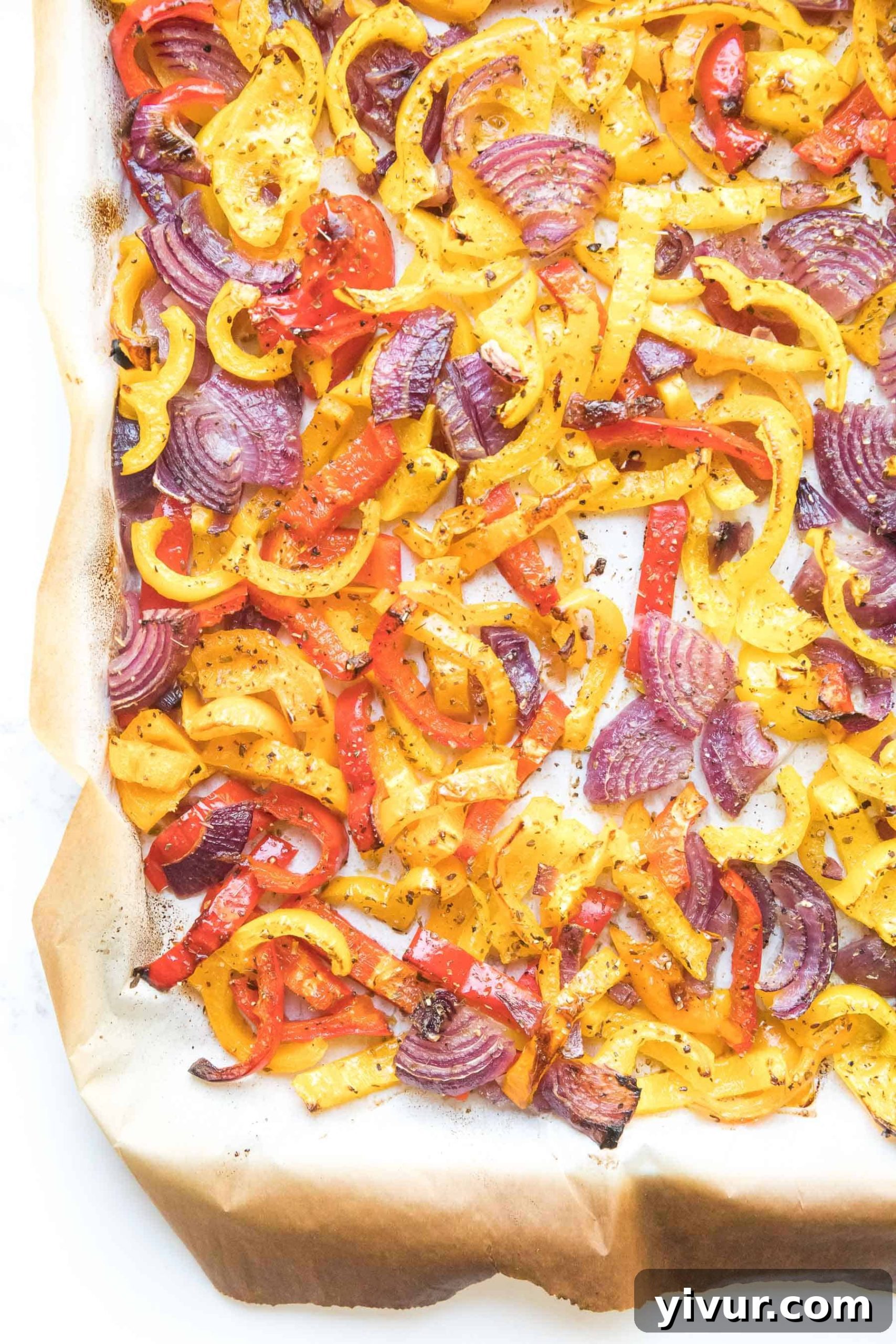 Vibrant bell pepper and onion fajita veggies artfully arranged on a sheet pan, ready for roasting