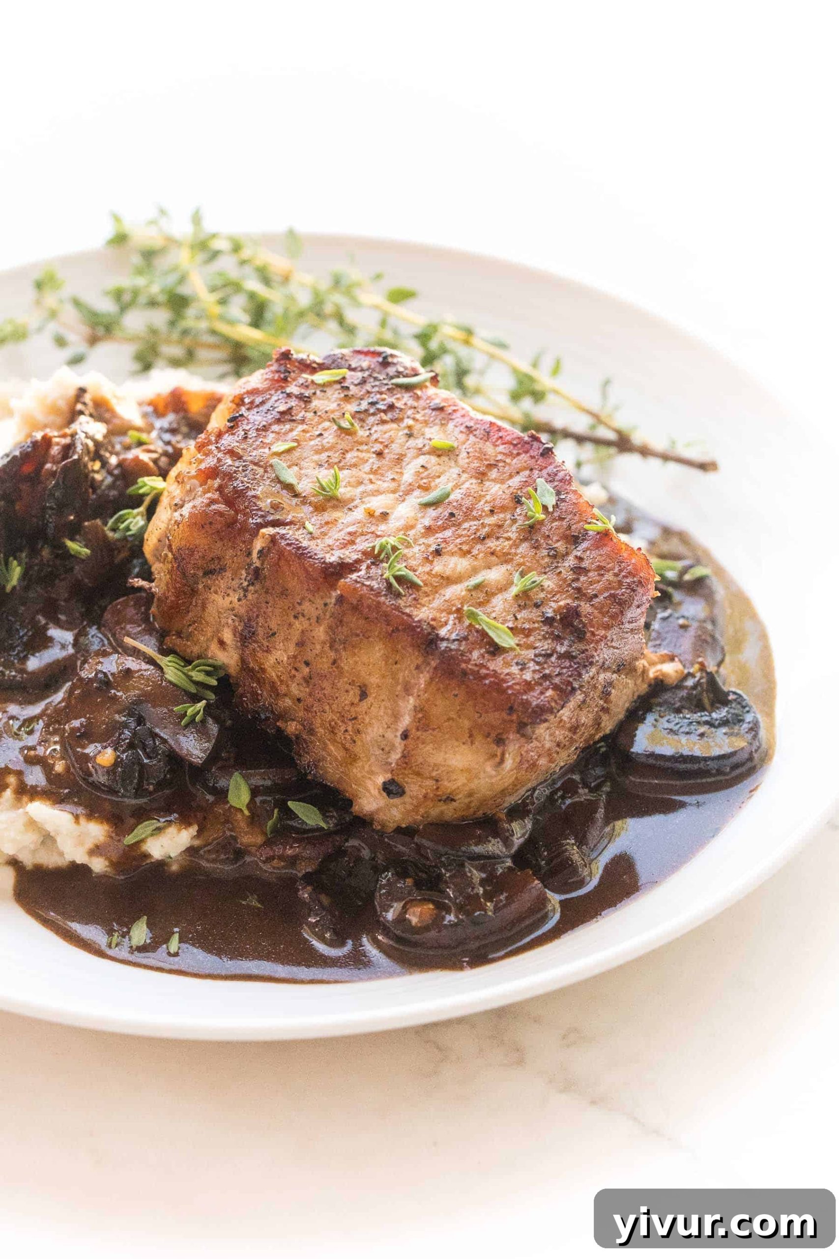 Ultimate Whole30 Keto Pork Chops with Creamy Bacon Mushroom Sauce 3 Close-up of perfectly seared pork chops glistening with savory bacon mushroom sauce, ready to be enjoyed as a healthy low-carb meal.
