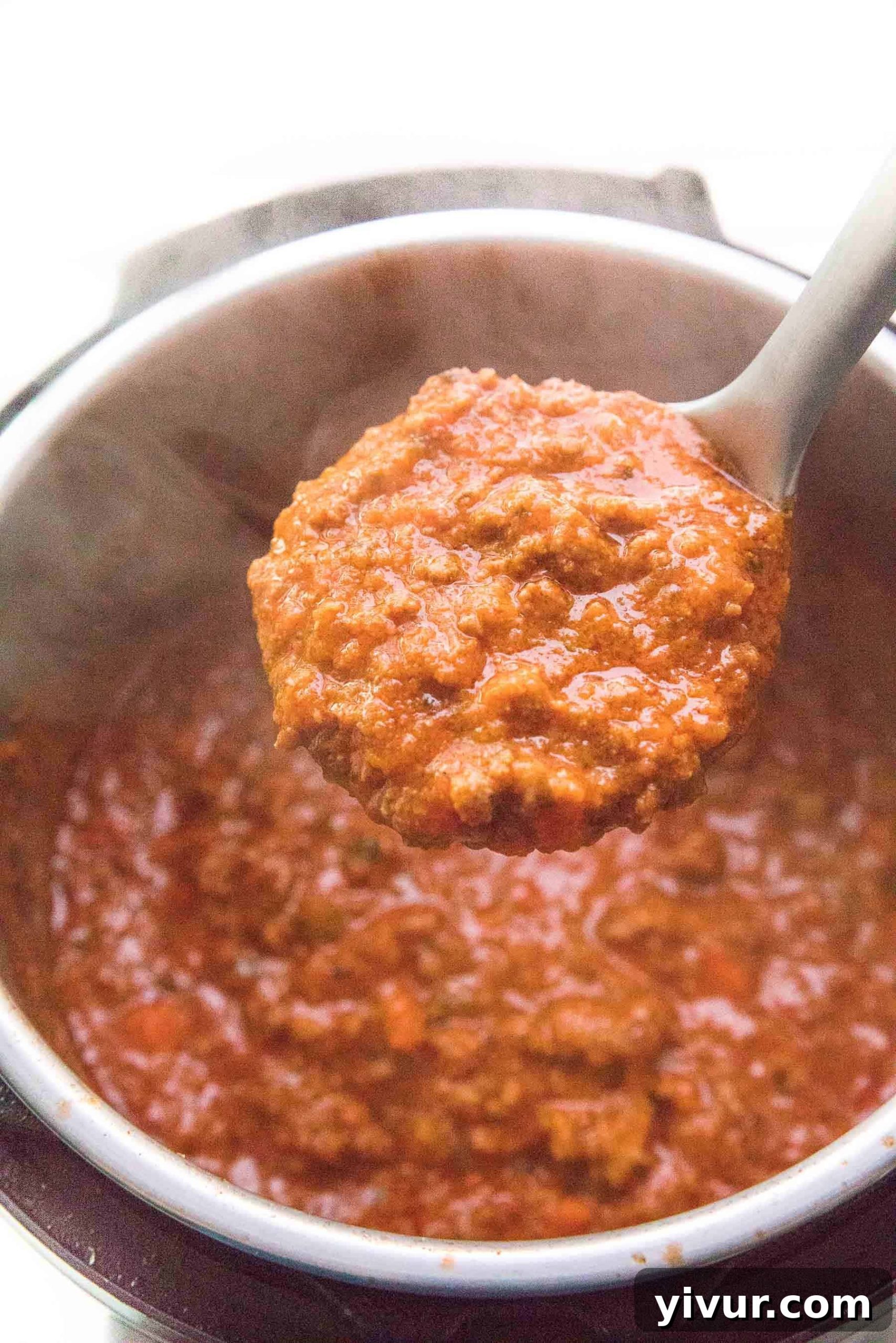 full ladle spooning out bolognese sauce from an instant pot