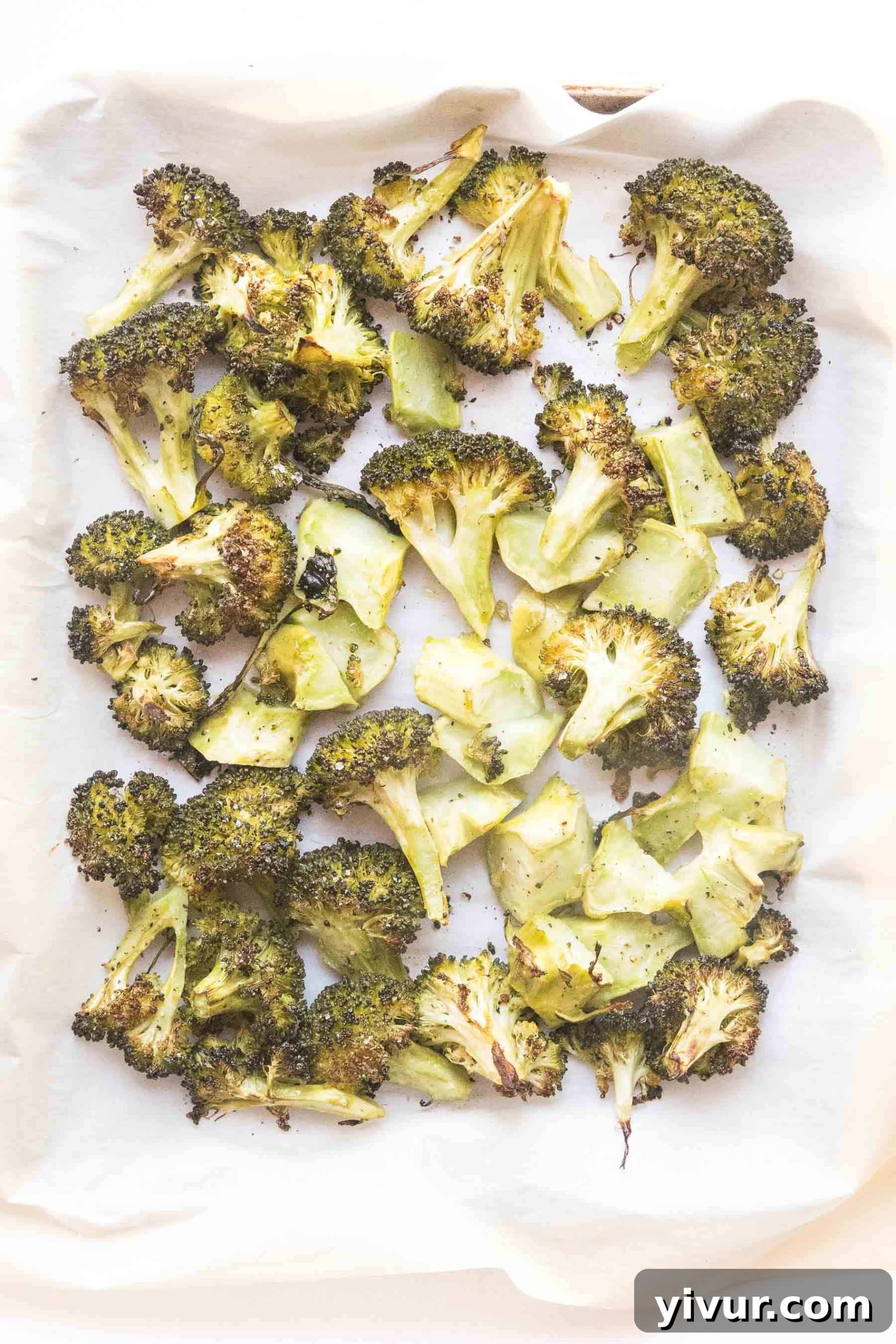 Perfectly roasted broccoli florets with crispy edges on a baking sheet, ready to serve.