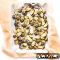 Roasted Brussels sprouts in a bowl with flaky salt