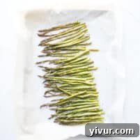 Roasted asparagus on a rimmed baking sheet, ready to serve