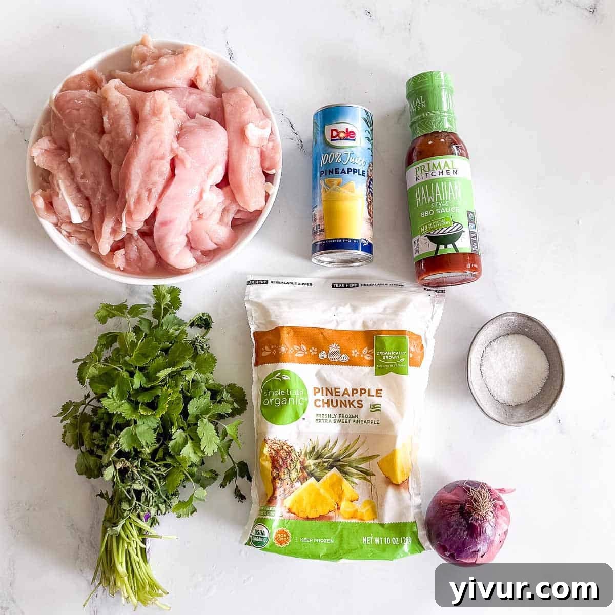A clean, top-down shot displays the fresh, vibrant ingredients for Hawaiian Chicken Bowls spread across a white surface. Raw chicken strips are ready for cooking, alongside a can of pineapple juice, a bottle of Hawaiian BBQ sauce, and fresh cilantro. Frozen pineapple chunks are shown, hinting at a time-saving hack, accompanied by a bright red onion and a sprinkle of salt. These components collectively promise a delicious, high-protein meal, ready to be prepared in an Instant Pot.